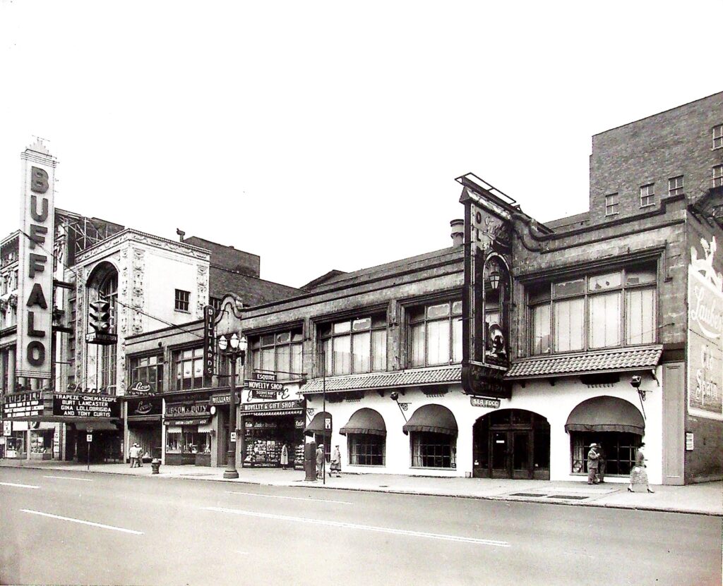 At the time this photo was taken, Laube's Old Spain (the future site of Shea's Smith Theatre) had moved in next door. That mural on the brick wall is still here today!