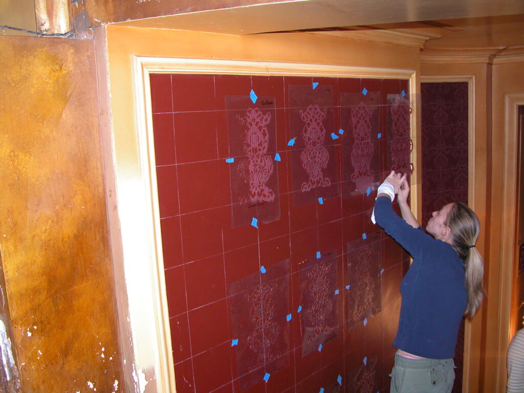 Originally, the walls of Shea's Buffalo Theatre lobbies were covered in a velvety wallpaper. Restoration Consultant Doris Collins got permission from the National Register of Historic Places to instead recreate the effect over nearly 7,000-square-feet through hand-drawn stencils, all done by volunteers. "The fabric was quoted as costing $200,000; I haven't spent $2,000 yet to do the same coverage." Doris Collins said.